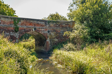 Fototapeta na wymiar Brick bridge over the Honing Canal in Norfolk, UK