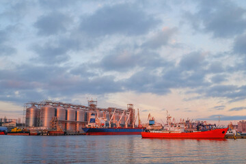 Bulk carrier ship in river port. Dry cargo grain elevator trade. Agrarian maritime facility. Cargo...