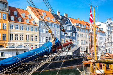 Fototapeta na wymiar Copenhagen iconic view. Famous old Nyhavn port in the center of Copenhagen, Denmark during summer sunny day with a boat on the foreground.