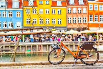 Copenhagen iconic view. Orange bike against famous old Nyhavn port in the center of Copenhagen,...