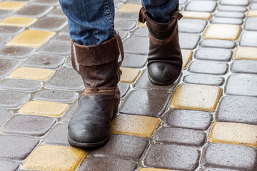 Leather boots on a wet sidewalk in the rain. Close up.