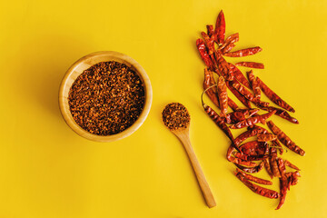 Dried red chili peppers Guajillo and chili powder spice on yellow background