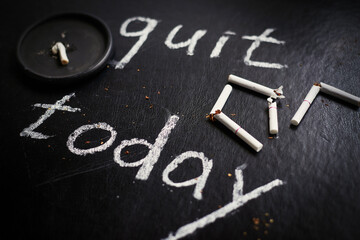 Fototapeta premium Stop smoking today concept. Broken cigarettes and inscription- quit today.