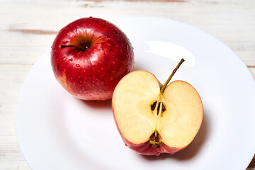 Naklejka na ściany i meble Ripe red apples on a plate on a wooden background.