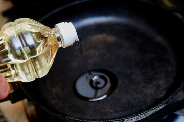 Pour oil into a hot pan. Preparation for frying products.