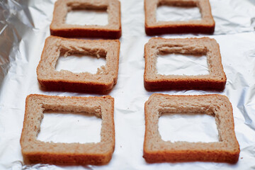 Making sandwiches from toast bread. Cut middle in toast for toppings.