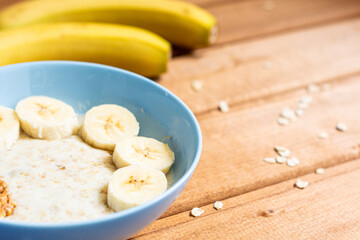 the view from the top. on a wooden table, oatmeal with a banana and walnuts for Breakfast, close-up