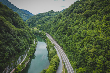 Fototapeta na wymiar Panorama of tight river valley with cramped railway line and road next to a wide green Sava river close to Hrastnik and Trbovlje.