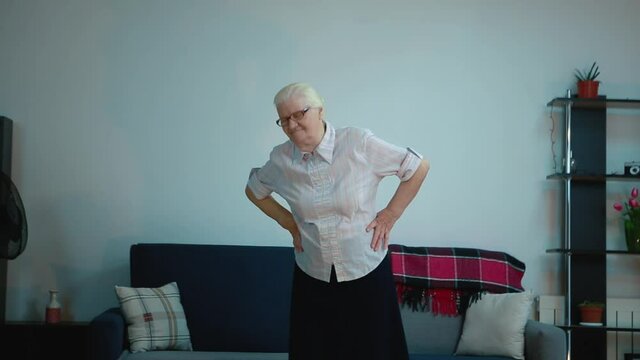 Elderly woman does exercises at home.