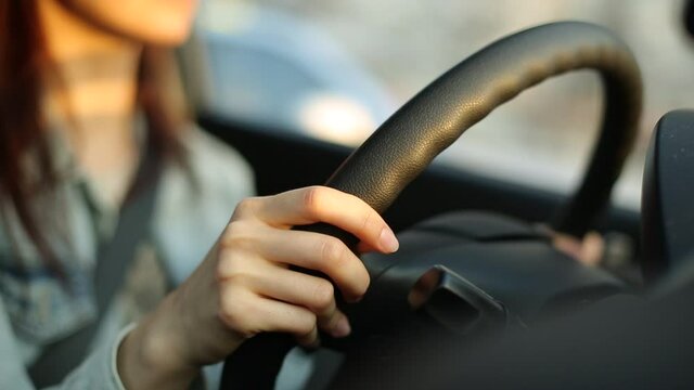 close-up of a car steering wheel with female hands on it