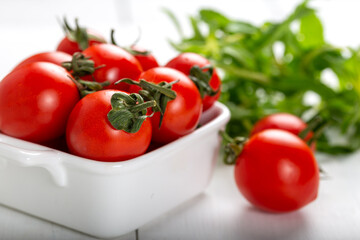 Cherry tomatoes in a bowl with basil and garlic