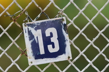 Vintage grunge square metal rusty plate of number of street address with number. Close up, brand.