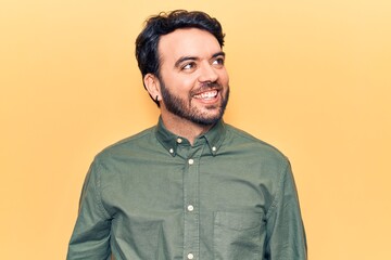 Obraz premium Young hispanic man wearing casual clothes looking away to side with smile on face, natural expression. laughing confident.