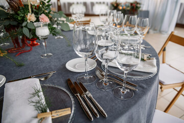 elegant table setting. napkins are pressed with clothespins. wooden chairs and a gray tablecloth