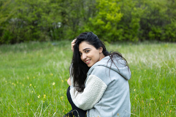 happy woman sitting in green grass