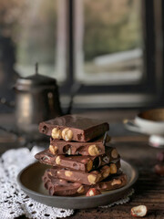 stack of chocolate bars with nuts on a wooden table