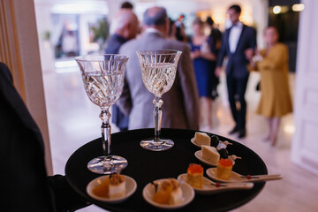 waiter serving champagne. guests in the blur in the background
