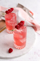 Pink rose cocktails with raspberry in crystal glass on table