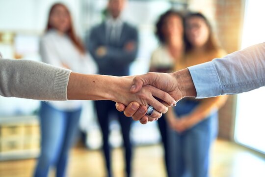 Group of business workers standing together shaking hands at the office