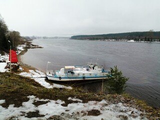 Obraz premium Old pleasure ship stands on the bank of a wide river in late autumn or winter