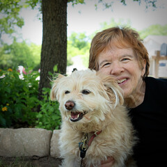 Senior woman with dog under a tree