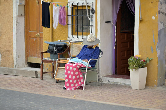An elder spanish lady sleeps on a chair in front of her house in Finestrat-Spain. 