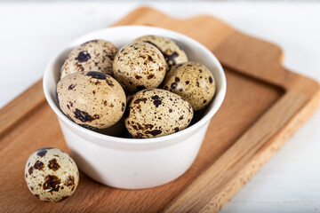 quail eggs in bowl on wooden table