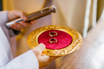 Closeup of a golden wedding rings in church during ceremony