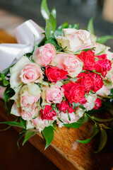 Bride holding a wedding bouquet of white and red roses