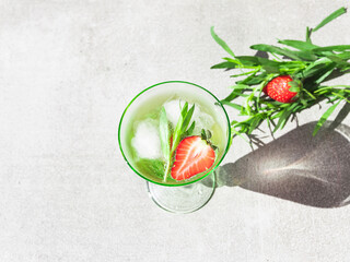 refreshing summer cocktail drink lemonade with ice, strawberries and tarragon in a glass