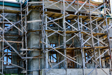 Wooden scaffolding near the old building. Ancient building restoration