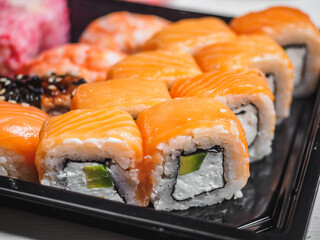 Set of sushi rolls in delivery plastic boxes on white background