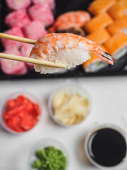 Sushi with prawn shrimp rice in wooden chopsticks