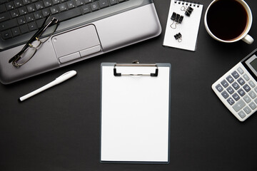 Top view of modern black office desk with laptop, notebook, pencil and a lot of things. Flat lay table layout. Copy space for text.