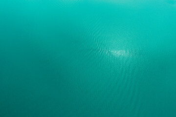 Azure Texture of the surface of lake water. Tropical calm background for design. Aerial shot top to...