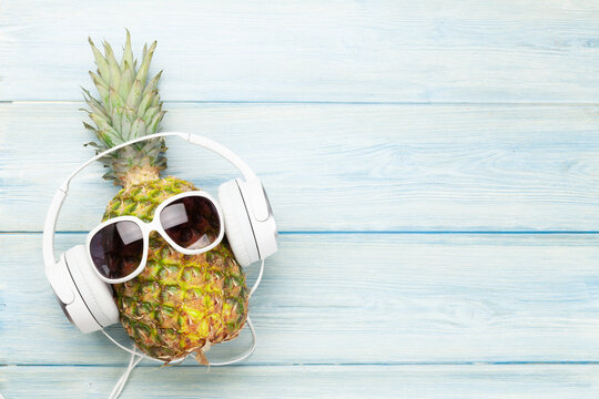 Ripe pineapple with sunglasses and headphones