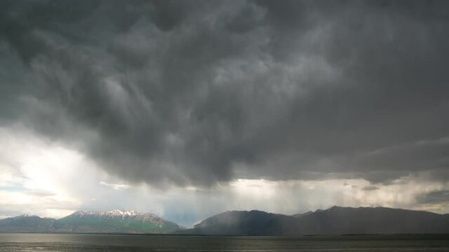 Rain storm time lapse moving over Utah Lake with dark clouds looking towards Timpanogos Mountain.