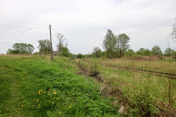 Fototapeta na wymiar abandoned railroad tracks in the spring field