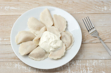 Fototapeta na wymiar dumplings with sour cream on a plate