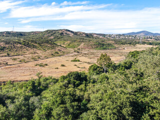Fototapeta na wymiar Aerial view of Los Penasquitos Canyon Preserve during dry season. Urban park with mountain, forest and trails in San Diego, California. USA