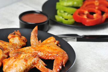 fried marinated chicken wings on a black plate