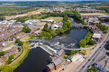 Aerial photo of the village centre of Castleford in Wakefield, West Yorkshire, England showing the main street along side the River Aire on a bright sunny summers day