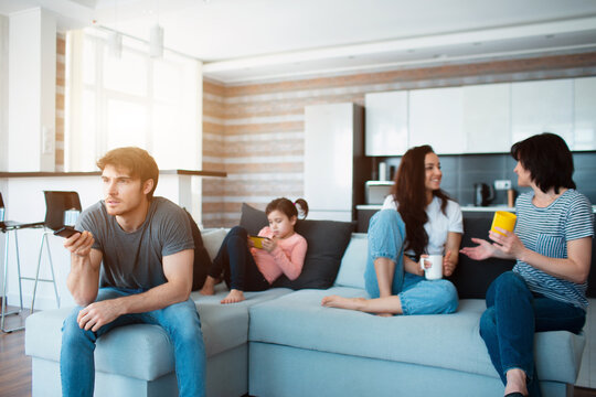 Big Family Is Sitting On The Sofa. Everyone Is Busy With His Own Business.