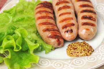 grilled fried sausages on plate with salad leaves and peppers