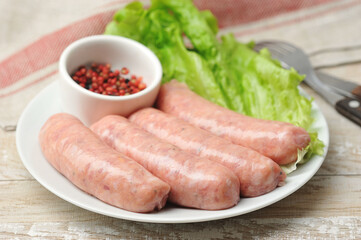 raw kupaty on a plate with lettuce and pepper