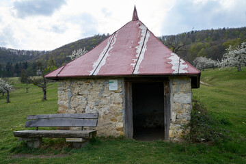 Obraz premium Stone hut for sheep shepherds on a green meadow in spring in south germany