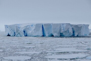 Closeup of blue iceberg at edge of pack ice in antarctic ocean, Antarctica