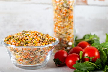 Colorful various beans or lentils and whole grains seeds or cereal in bowl with fresh vegetables.