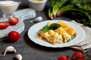 Caneloni pasta with spinach and ricotta, with bechamel sauce. 