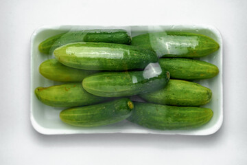 Green cucumber photos in white foam tray pack in white background
